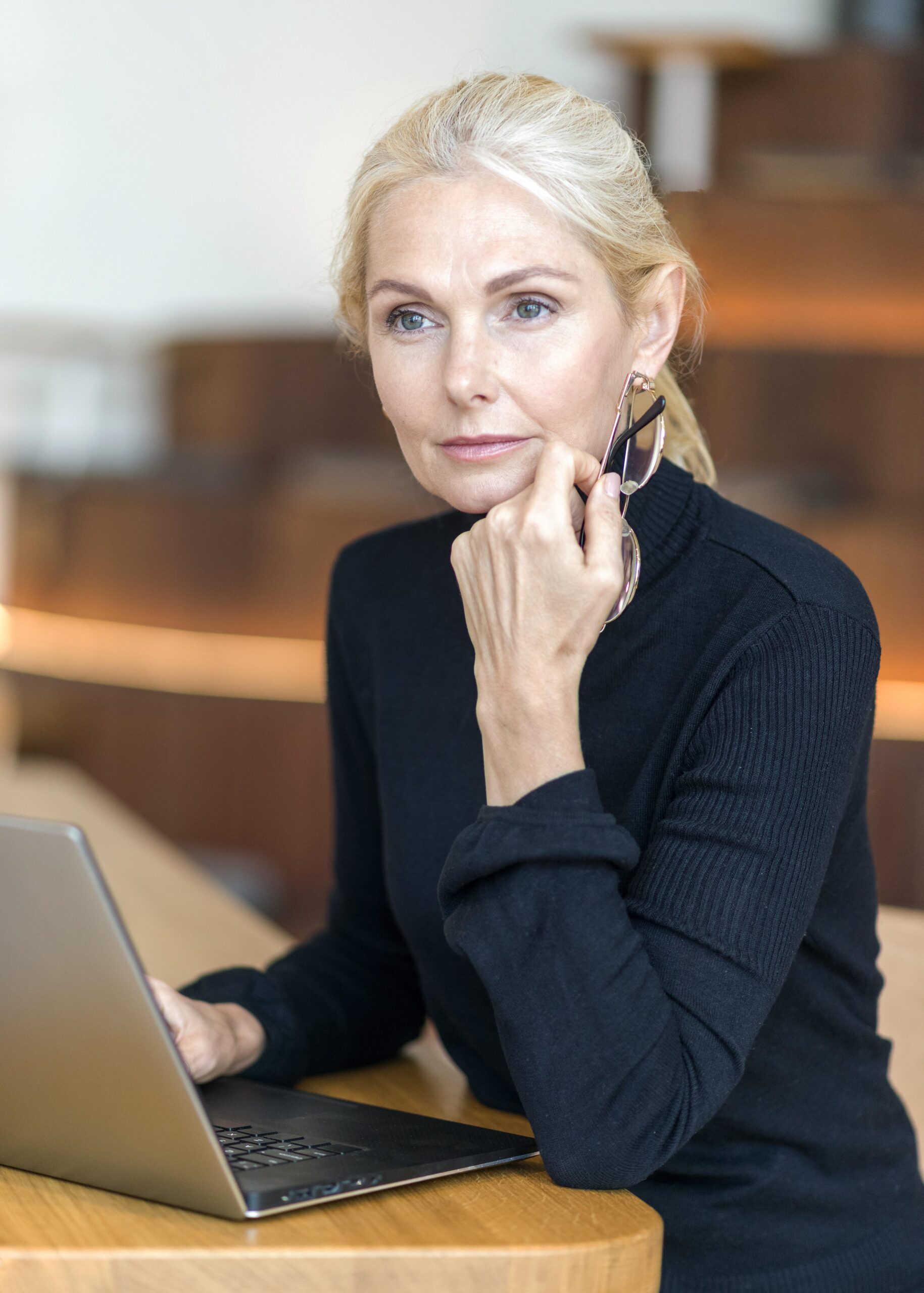 seitenansicht-der-fokussierten-alteren-frau-mit-brille-die-am-laptop-arbeitet